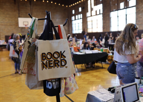 Bag with "Book Nerd" written on it in the foreground of a room full of people shopping